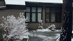 A house with a snow-covered roof, a paved driveway, and a snow-covered lawn. - Bike, Hike & Unwind. Heated Pool, Hot Tub and Sauna. (Mammoth Lakes)