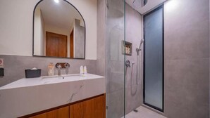 A modern bathroom with a glass-enclosed shower, a large mirror, and a wooden vanity. - 8035Coco Villa 2 Cemagi (badung)