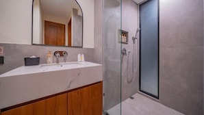 A modern bathroom with a glass shower enclosure, a large mirror, and a vanity with a marble countertop. - 8035Coco Villa 2 Cemagi (badung)