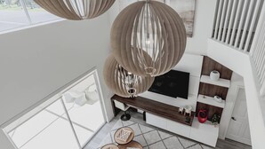 A modern interior with a large window, a sofa, a TV, and decorative hanging lamps. - Family Resort Pool Home Near Disney (Kissimmee)