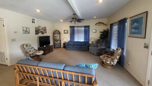 A living room with a sofa, two armchairs, a television, and a ceiling fan. - Waterview House by the Public Boat Ramp (Port O`Connor)