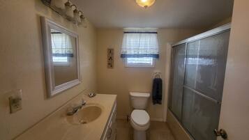 A bathroom with a sink, toilet, and shower.