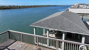 A pier with a covered seating area overlooking a calm body of water. - Beautiful Intracoastal Home with Two Boat Lifts and a Boat Slip (Port O`Connor)