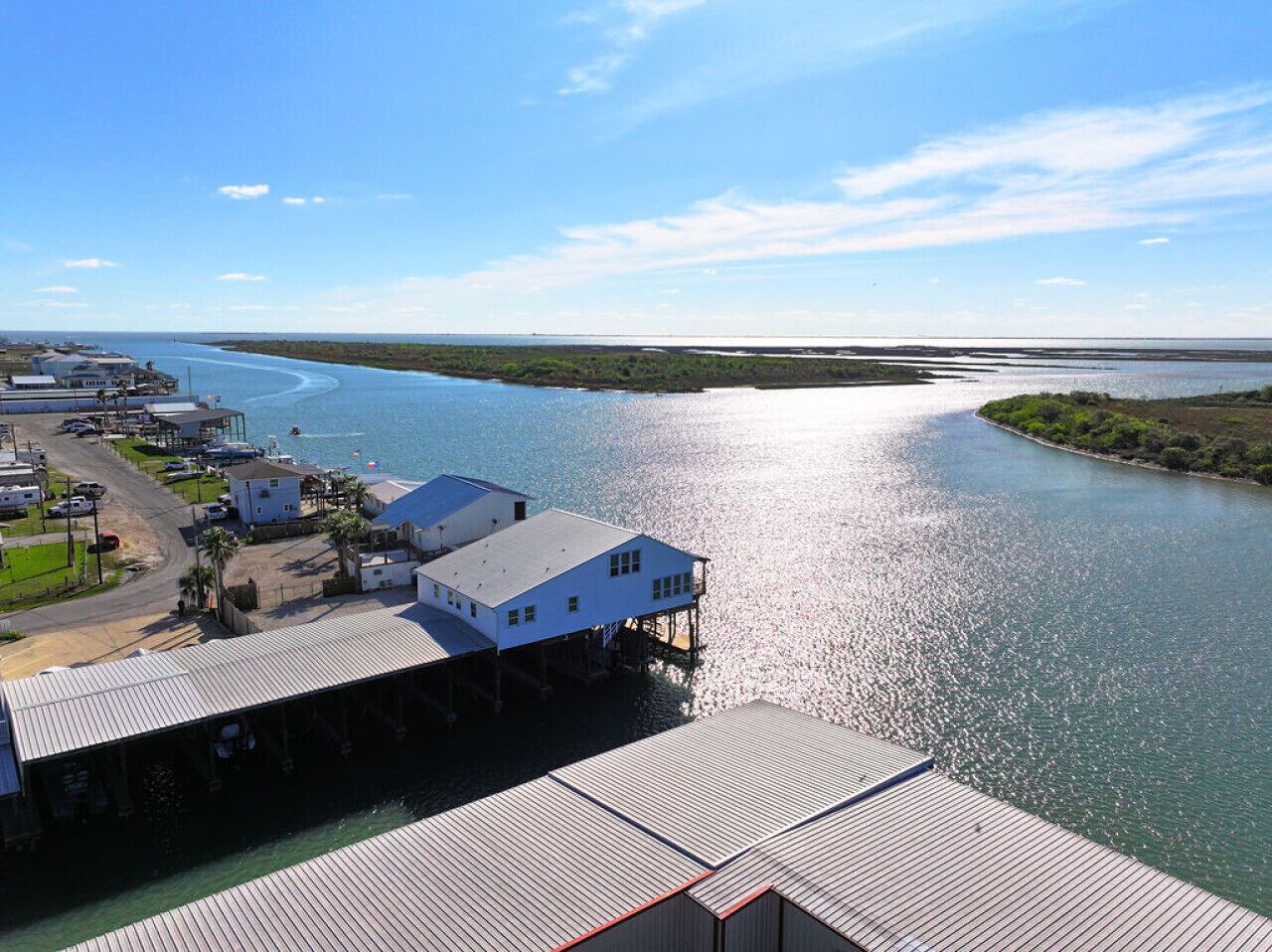 A waterfront property with a dock, a white building, and a marina.