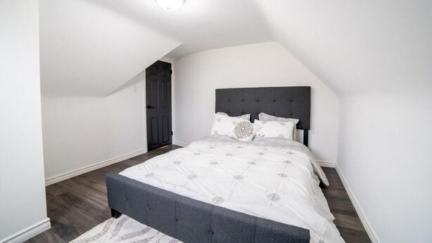 A bedroom with a bed, a dark headboard, and a ceiling light. - 2br, Welland Canal, Near Merritt, 20 Min To Falls (Welland)