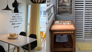 Moderni keittiö, jossa on riippuvalaisimet, ruokailutila pöydän ja tuolien kera sekä näkymä ulkona olevaan rakennukseen.