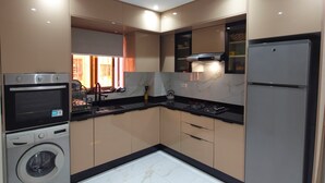 A modern kitchen with built-in appliances, marble flooring, and recessed ceiling lighting. - 
Apartment cosy modern and luxury Marrakech (Marrakesh)