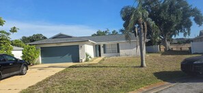 A residential house with a garage, a driveway, and a lawn. - 2-bedroom/2-bath located minutes from Anna Maria Island and Gulf Beaches (Bradenton)