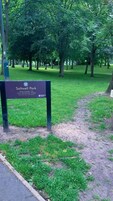 Señal en un parque que dice 'Saltwell Park, Bienvenidos al Parque del Pueblo' y 'Abierto desde el amanecer hasta el anochecer todos los días'.