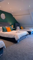 Un dormitorio moderno con dos camas, un espejo redondo e iluminación empotrada en el techo.