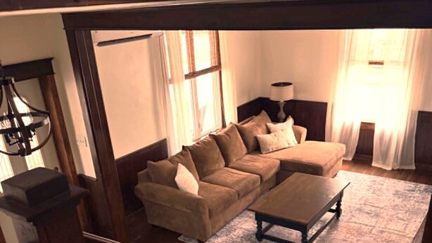 Una escalera que da a una sala de estar con un sofá, una mesa de centro y una lámpara.