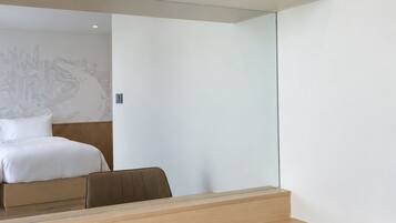 A hotel room with a bed, a desk, and a chair.