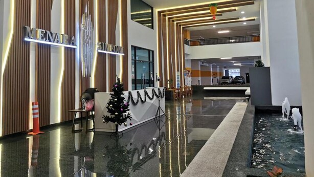 Eine moderne Hotellobby mit einer Rezeption, einem Weihnachtsbaum und einer Wasserspüle.