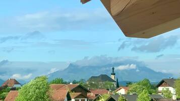 Un quartier résidentiel avec des maisons, une église et des montagnes en arrière-plan.
