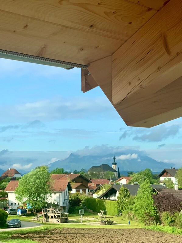 A residential area with houses, a church, and mountains in the background.