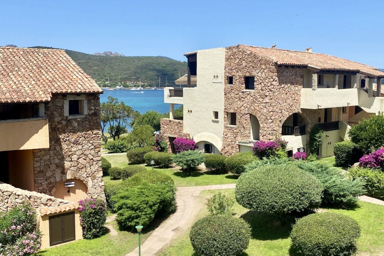 Ein Hotel an der Küste mit Gebäuden aus Stein und Stuck, einem gepflasterten Innenhof und Blick auf das Meer.