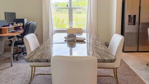 A dining area with a table, chairs, a computer setup, and a refrigerator. - Cozy 2-bedroom cottage with AC in cool Jacksonville 55+ community in Mandarin (Jacksonville)