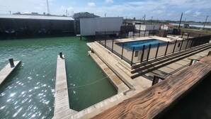 Une jetée avec une piscine et un bâtiment en arrière-plan.