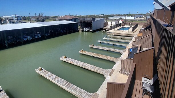 A marina with docked boats, a covered boat launch ramp, and a clear blue sky.