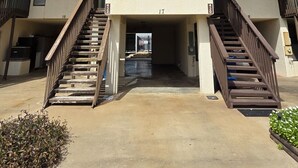 A two-story building with a sign for POC Rentals, a central entrance with a staircase, and a number 17 on the facade.