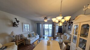 A spacious living room with a dining table, sofas, and a cabinet.