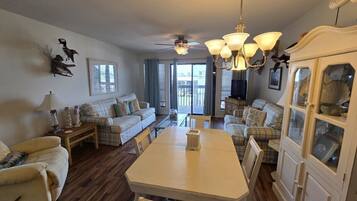 A spacious living room with a dining table, sofas, and a cabinet.