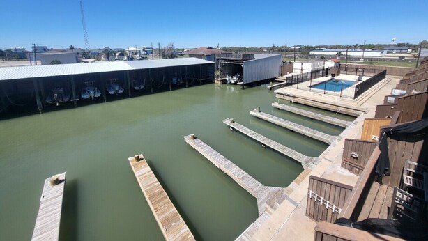 Une grande piscine intérieure dotée de plusieurs couloirs de nage, d’une plateforme de plongeon et d’un espace couvert avec une piscine.