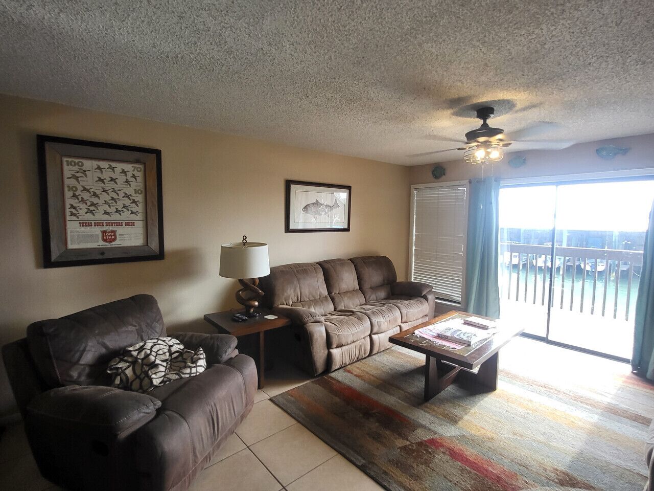 A living room with a sofa, a coffee table, a lamp, and a framed picture on the wall.