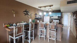 Une cuisine avec des tabourets de bar en bois, une cuisinière et un réfrigérateur.