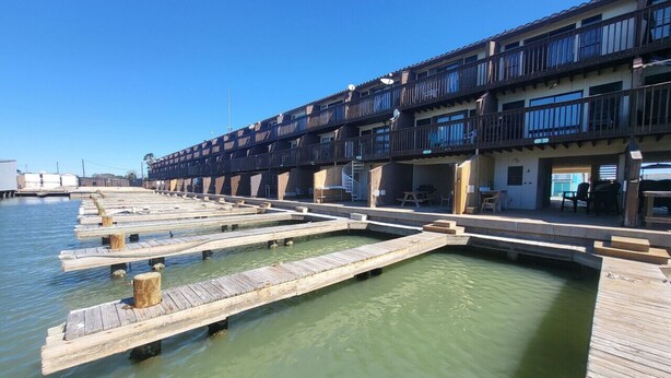 Hotel amb vistes al mar i passeres de fusta sobre l'aigua, balcons i zones d'estar a l'aire lliure.