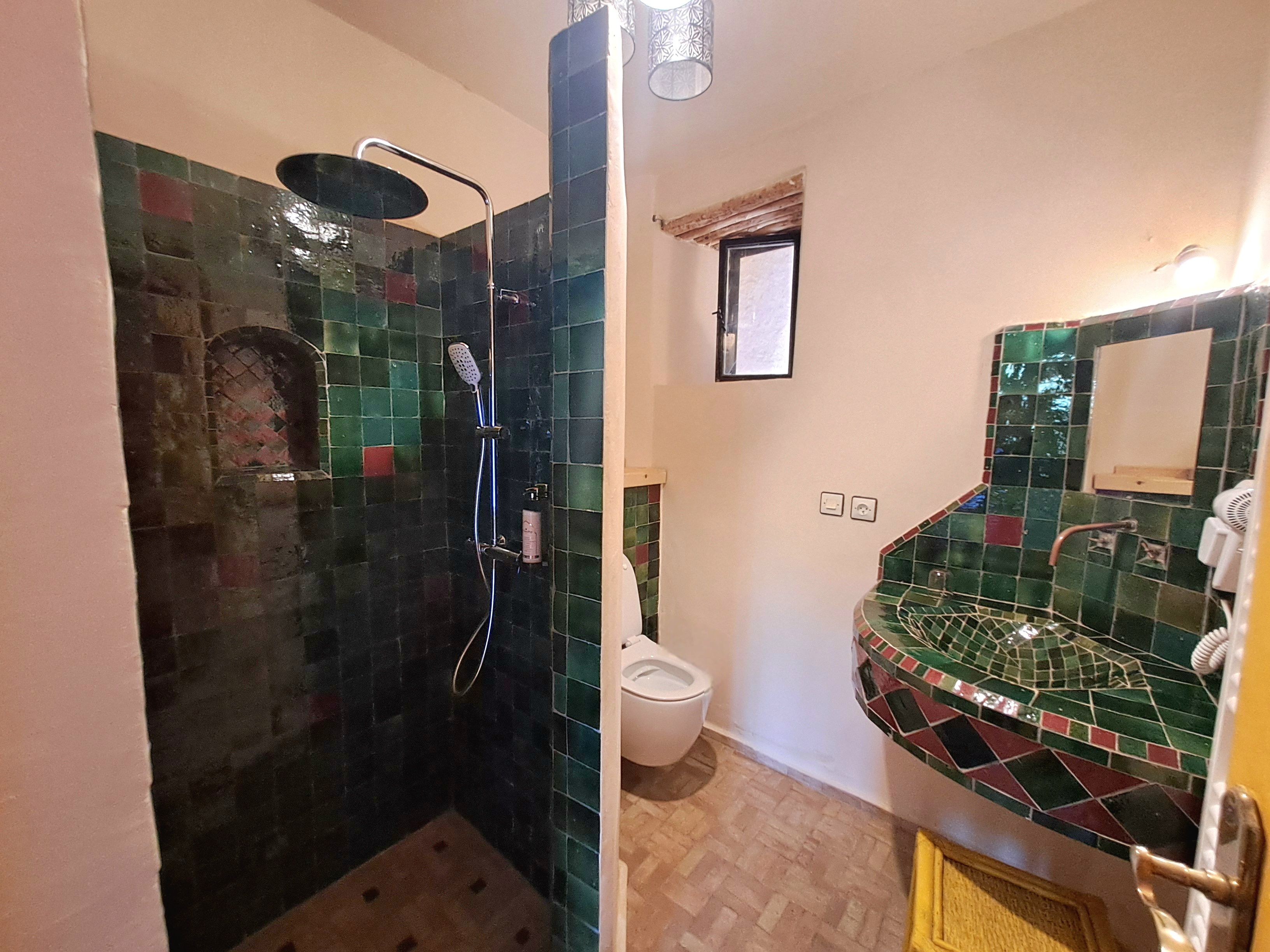 Et badeværelse med brusebad, toilet og håndvask.