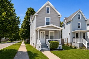 A two-story residential house with a front porch, a small front yard, and a sidewalk. - Willow & Mist - Gorgeous 3-bedroom house minutes from Niagara Falls attractions (Niagara Falls)