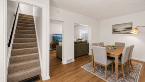 A modern apartment with a staircase, a dining area, and a living room. - Willow & Mist - Gorgeous 3-bedroom house minutes from Niagara Falls attractions (Niagara Falls)