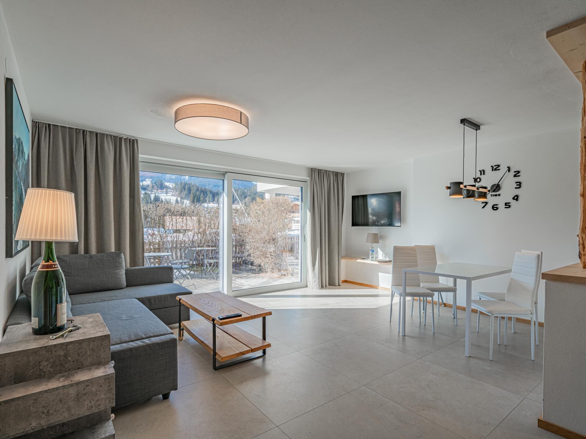 Ein modernes Wohnzimmer mit Sofa, Couchtisch und Essbereich.