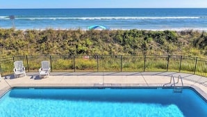 A swimming pool with a view of the ocean, a fenced area with chairs, and a sign indicating no diving. - A Wave From It All/4 bed 3 bath Pool Oceanfront (north Topsail Beach)