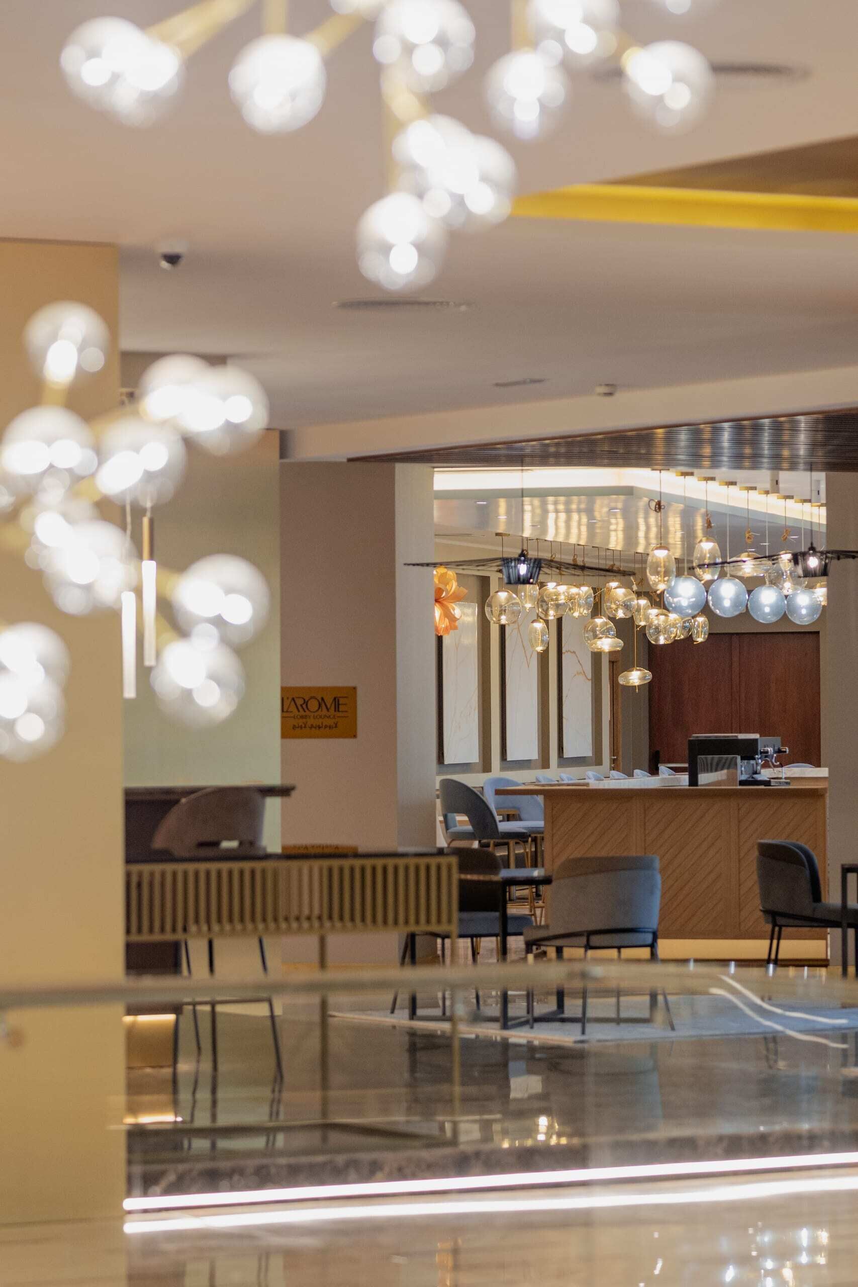 A modern lobby with a reception desk, seating area, and decorative lighting.