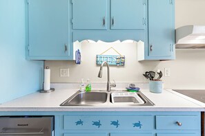 A kitchen with light blue cabinets, a stainless steel sink, and a Honeywell dishwasher. - 3 blocks to the Beach, Fishing Pier & over 12 restaurants - Spacious & Clean! (Oak Island)