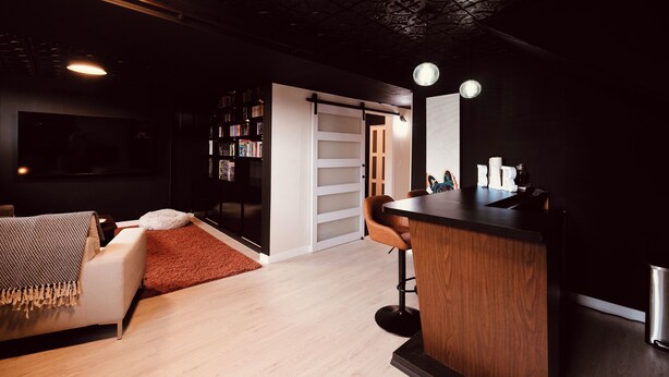 A modern interior with a bar area, a sofa, a bookshelf, and a patterned ceiling. - Gateway to the Gorge (Portland)