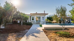 Una casa amb teulada de rajola, un porxo i una piscina.
