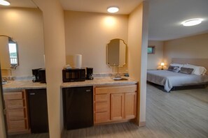 Une chambre d’hôtel équipée d’une kitchenette, d’un lit et d’une salle de bain.