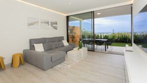 Un salon moderne avec un canapé gris, une table basse blanche et un coin repas comprenant une table et des chaises.