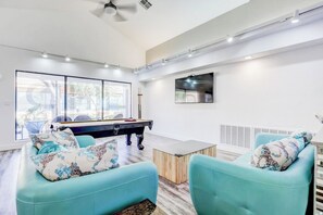 A modern living room with a pool table, two sofas, a coffee table, and a TV. - Newly updated cozy 2-bedroom condo with spacious balcony (St. George)