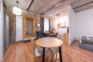 Ein modernes Wohnzimmer mit einem Holzesstisch, einer Couch, einem kleinen Fernseher und einem Kamin.