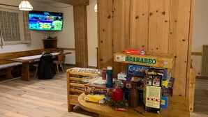 Un interior de madera con una barra de aperitivos que ofrece diversos alimentos y un televisor que muestra un canal deportivo.