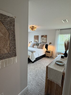 A bedroom with a bed, bedside tables, a lamp, and a window with blinds. - Navarre Beach Brand-new townhome! (Navarre)
