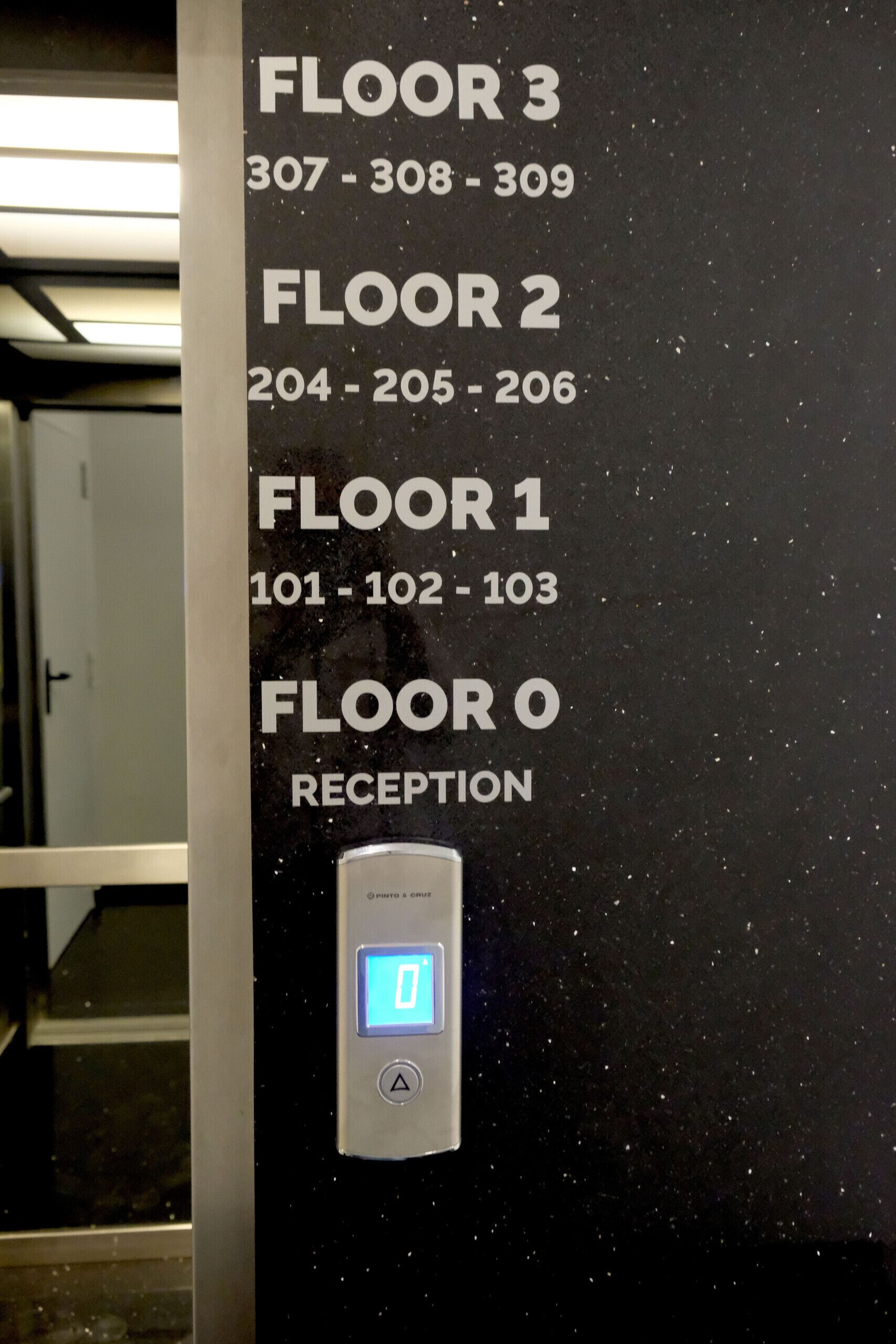 Ein Hotelausweis mit Zimmernummern für die Etagen 1 bis 3 und der Rezeption in der 0. Etage.
