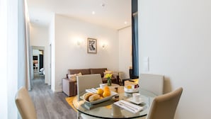 A modern dining area with a glass table, chairs, and a breakfast setting. - Letheshome Apartments 205 (Oporto)