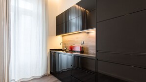 Eine moderne Küche mit dunklen Schränken, einer Holz Arbeitsplatte und einem roten Toaster.