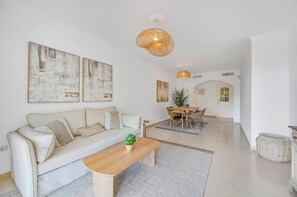 Ein modernes Wohnzimmer mit einer Couch, einem Couchtisch und einem Essbereich.