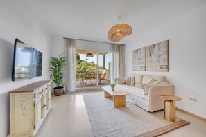 Ein modernes Wohnzimmer mit Sofa, Couchtisch und einem Essbereich mit Tisch und Stühlen.